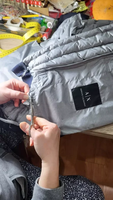 Arreglo Abrigo Plumas Diseñador Modista Rafelbunyol Rosa, modista de Arreglos con Rosa, realizando un arreglo en un abrigo de plumas de la marca Armani. Servicio especializado en Rafelbunyol.